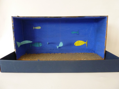 Meine Installation stellt das Meer dar. Ich habe Sand an den Boden geklebt und das Innere der Schachtel blau angemalt. Auen habe ich Schwarz gewhlt, um die Dunkelheit in den Meerestiefen darzustellen.