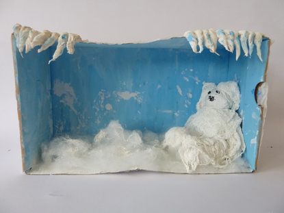 Zuallererst habe ich meine Installation mit Klopapier bedeckt. Als der Kleister getrocknet war, f�llte ich den Boden der Schachtel mit Watte, diese soll den weichen, wei�en Schnee darstellen. Von oben h�ngen wei�e Zapfen, die die K�lte symbolisieren.